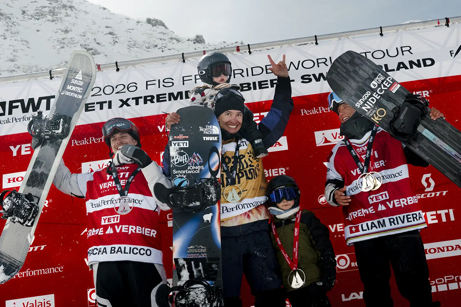 Snowboard winners celebrating on the podium at a competition.