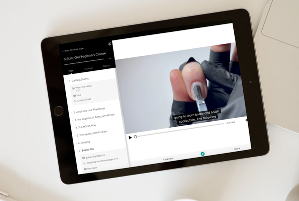 A tablet displaying a video tutorial on a nail procedure.