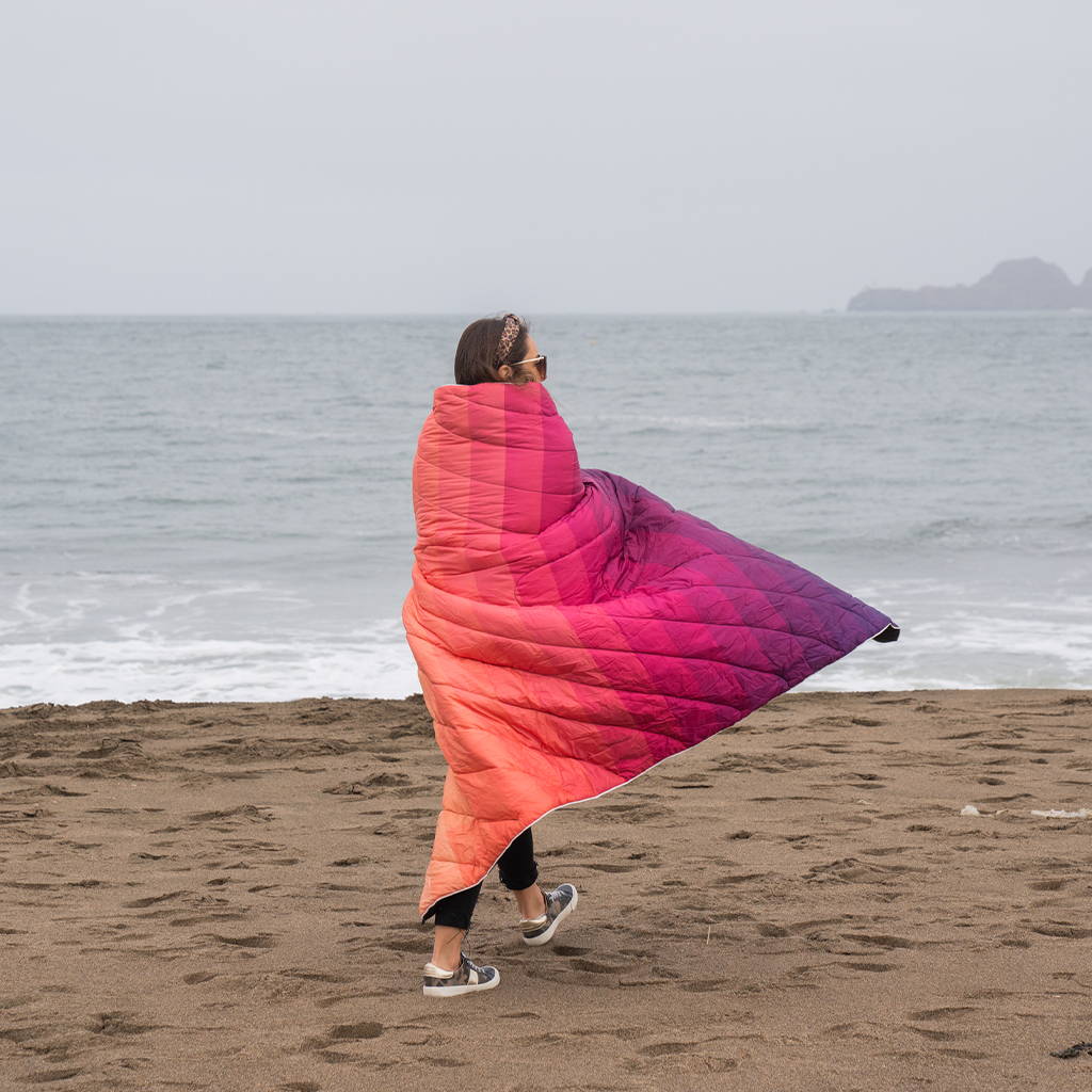 Pearson wearing Rumpl blanket on beach