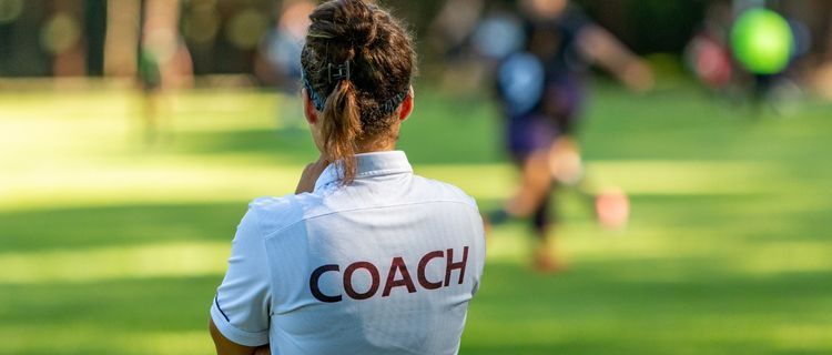 School coach on field wearing white Valour polo