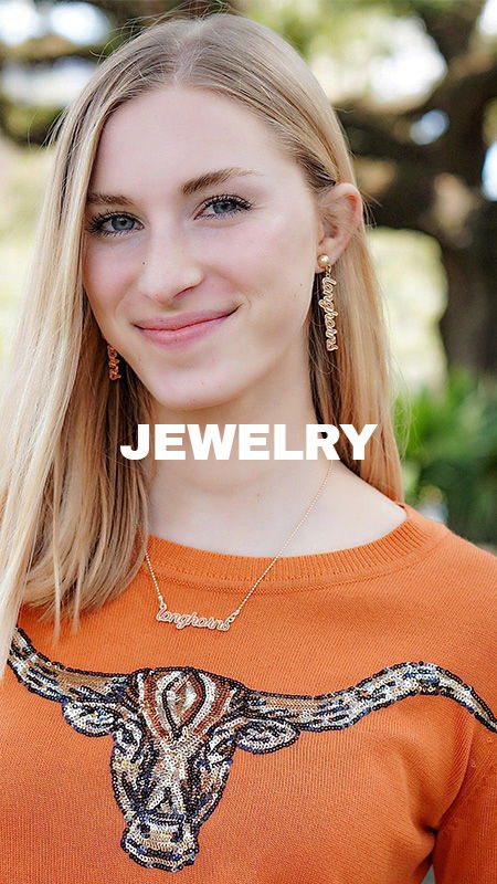 Young woman wearing jewelry and an orange sweater with a decorative design.