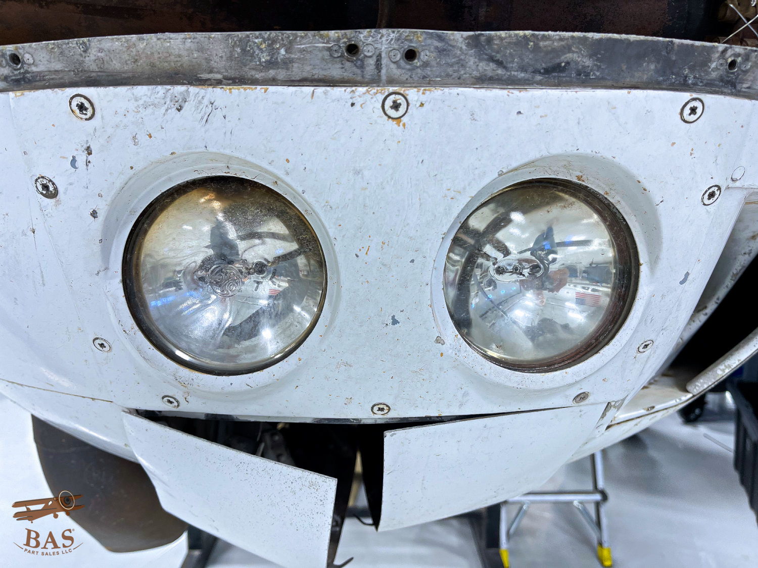 Close-up of two round headlights on a white surface.
