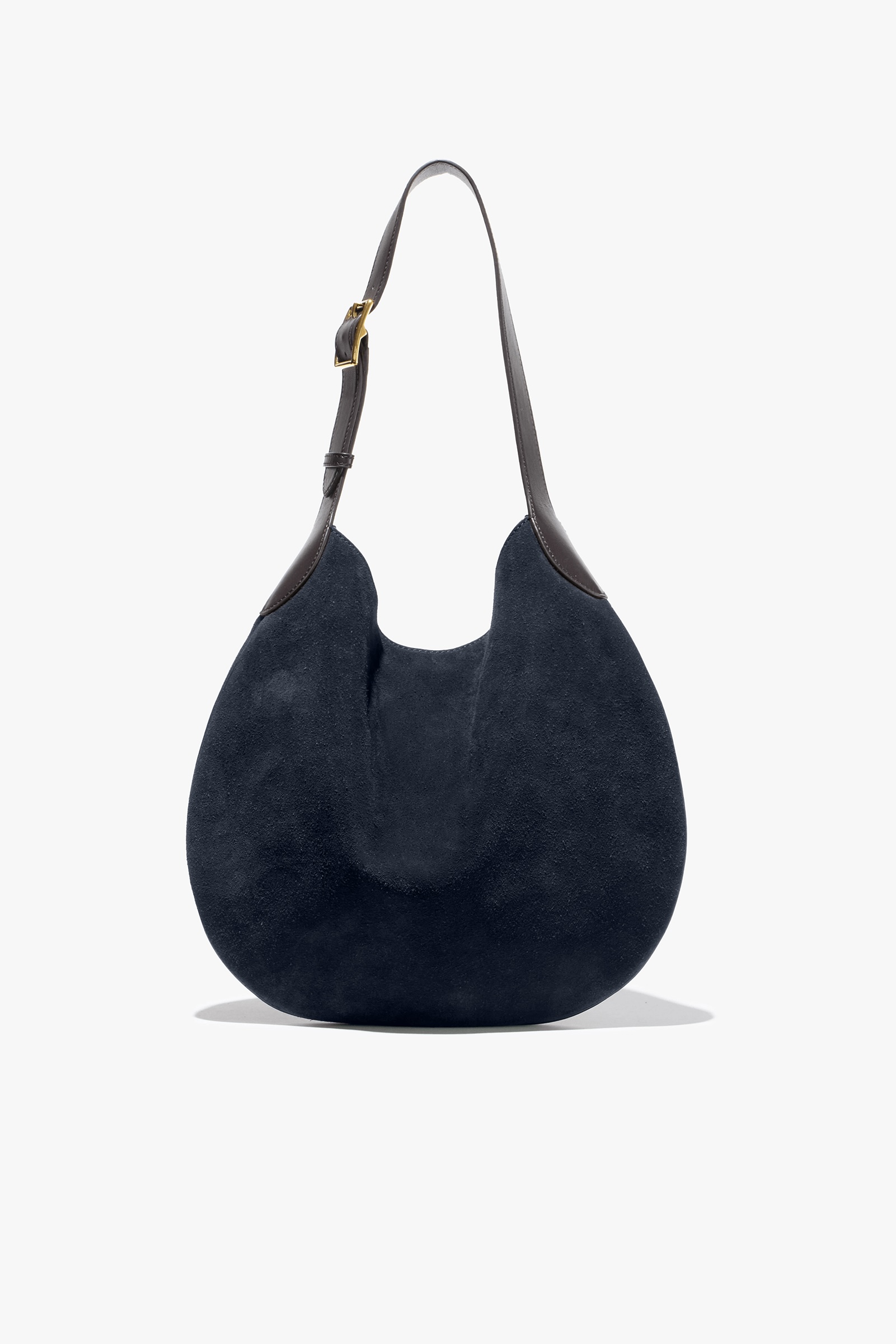 Navy suede shoulder bag with a curved shape and adjustable strap.