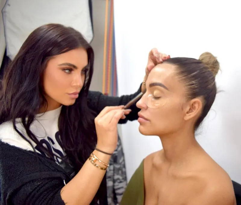 makeup artist putting concealer on a client 