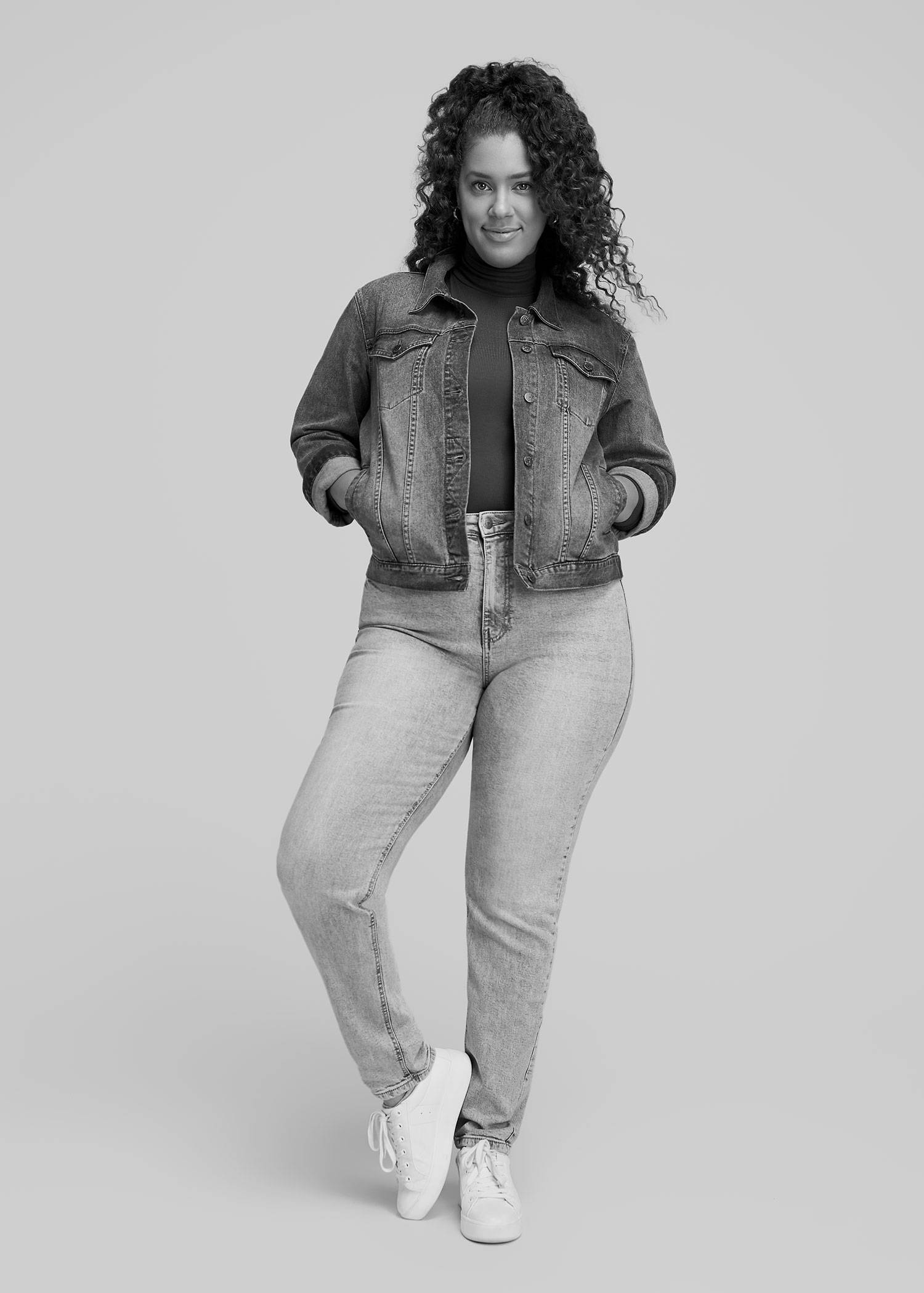 A tall woman wearing a denim jacket and light wash jeans