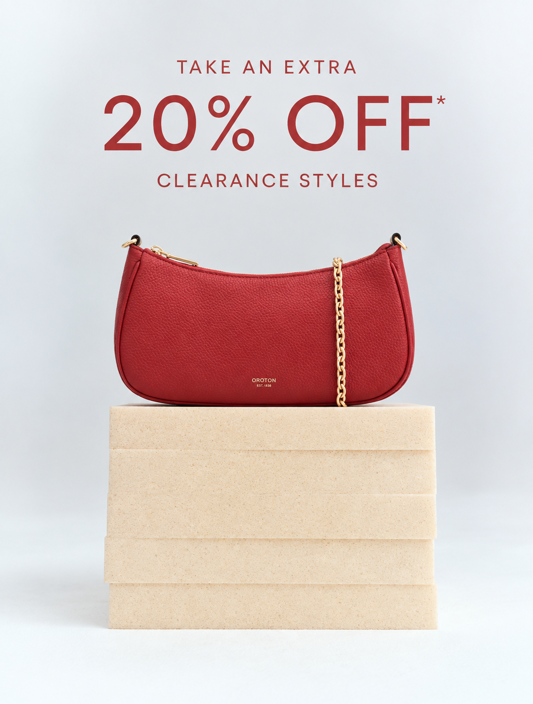 Red handbag on stacked boxes with discount promotion text.