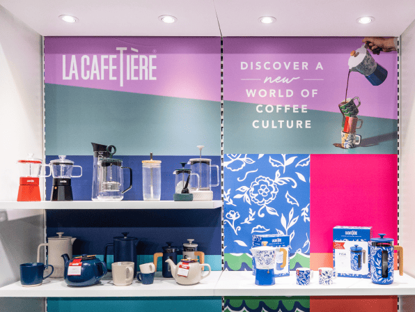 Display of coffee products with colorful branding and promotional text.