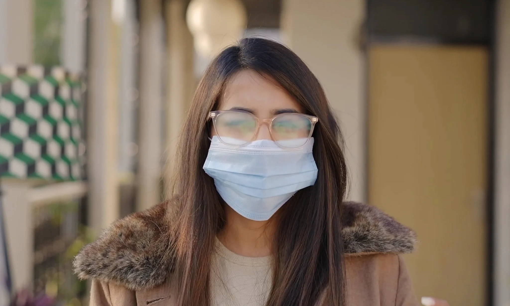 Woman wearing fogged glasses and a mask