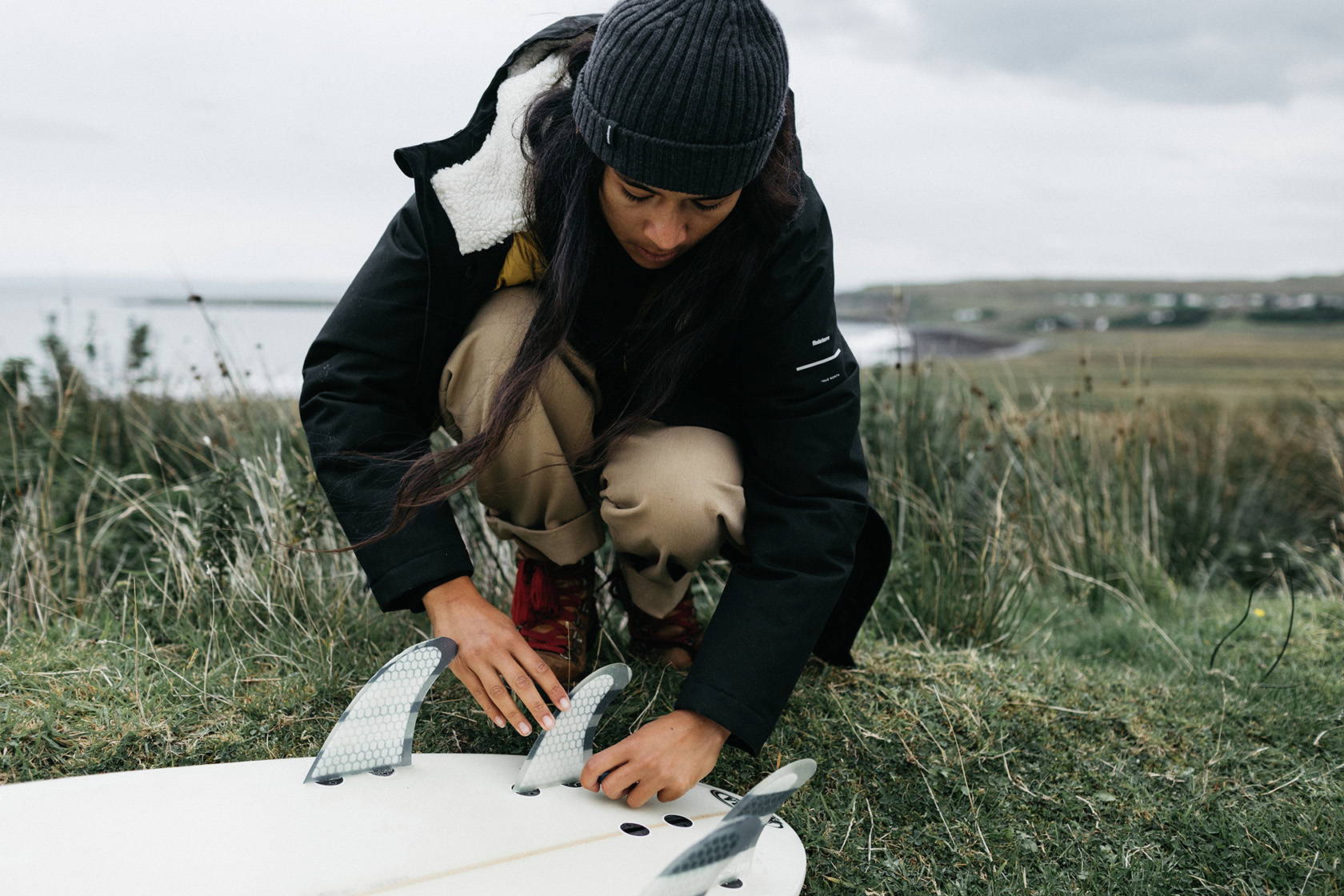 Steph wearing Finisterre Vellus Parka with surfboard