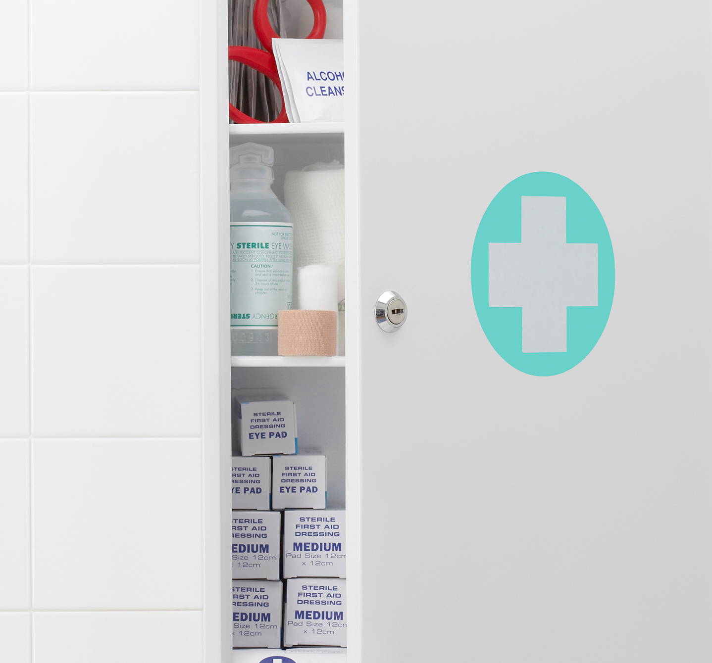 Badezimmerschrank mit weissem Kreuz auf einem mintgrünen Kreis auf halb offener Tür, in dem dein Allergiemedikament stehen könnte.