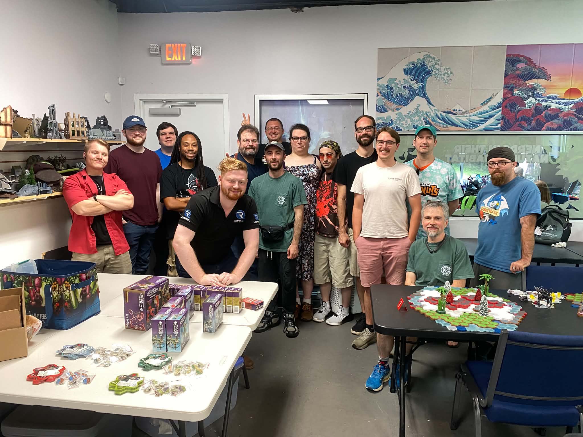 Group of people posing together in a gaming or hobby store.