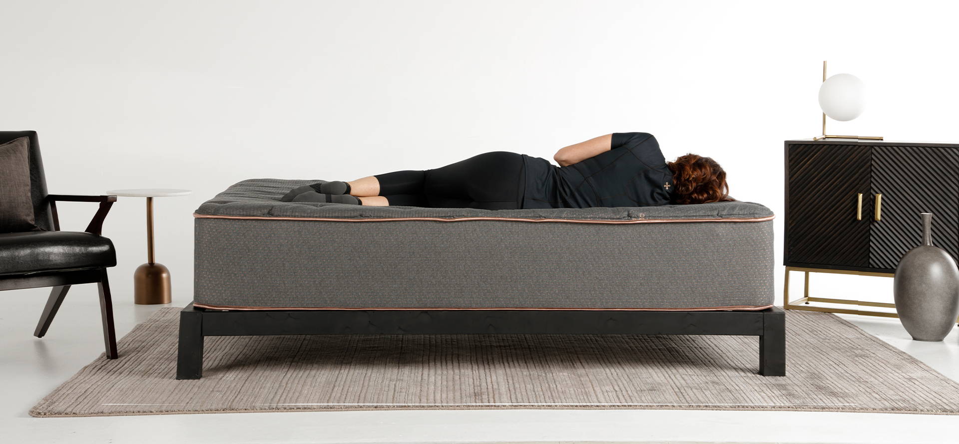 A woman laying on a Tommie Copper Mattress