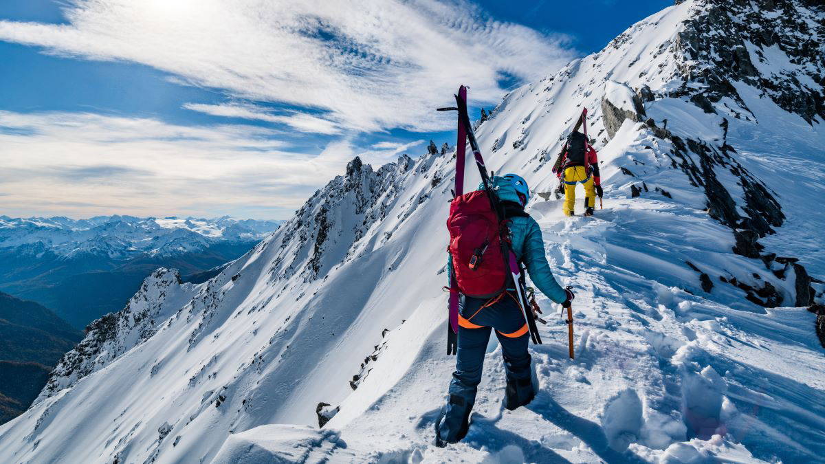 Two mountain climbers on a snowy mountain peak with Garmin inReach satellite communicator