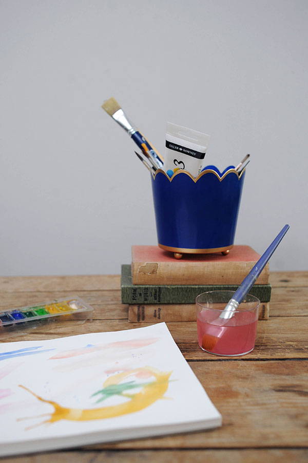 Art supplies and paint pad with brushes in a Tooka small scallop planter in royal blue.