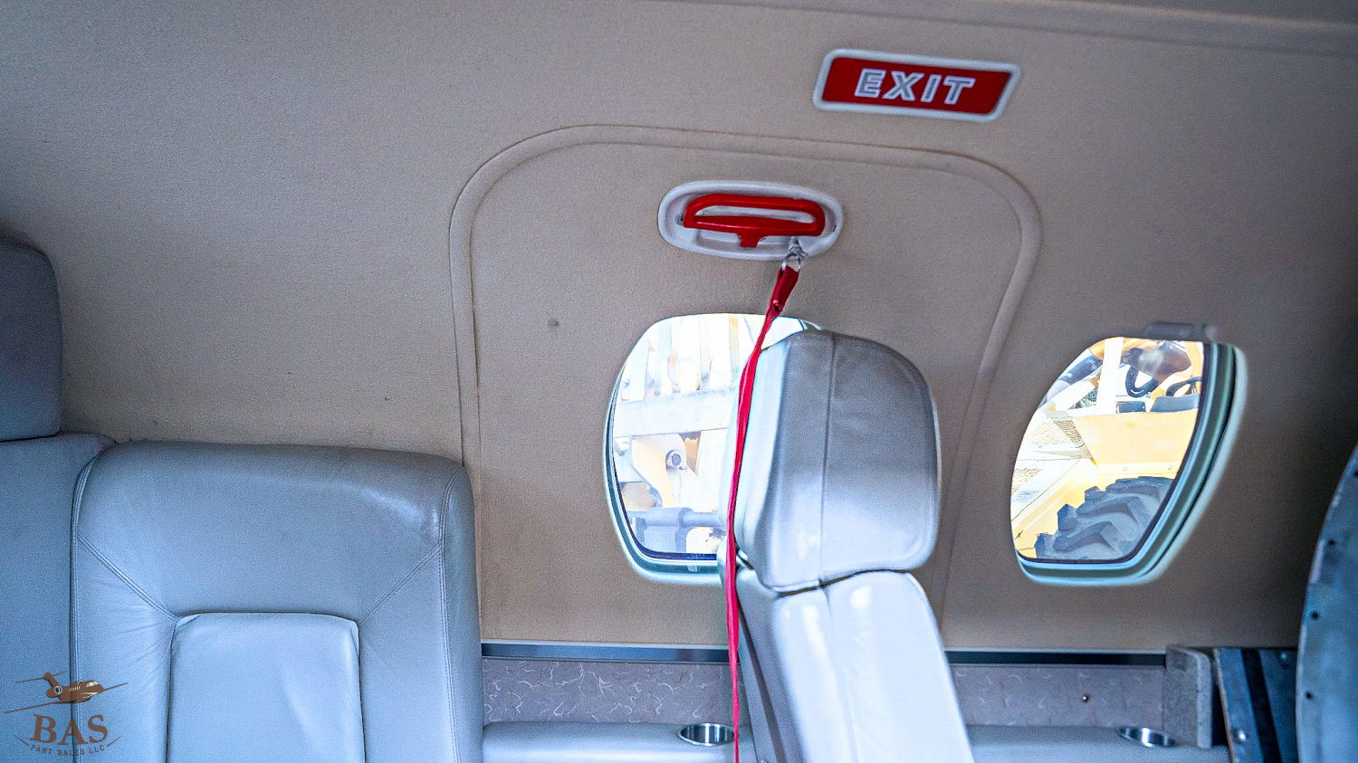 Interior of an aircraft showing exit sign and windows.