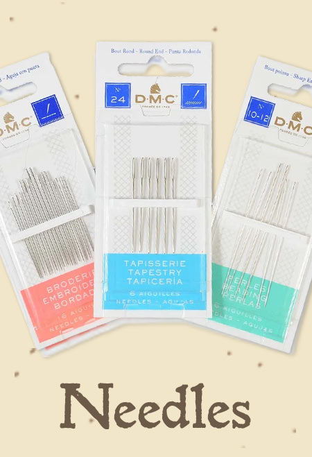 Three DMC packages of sewing needles.