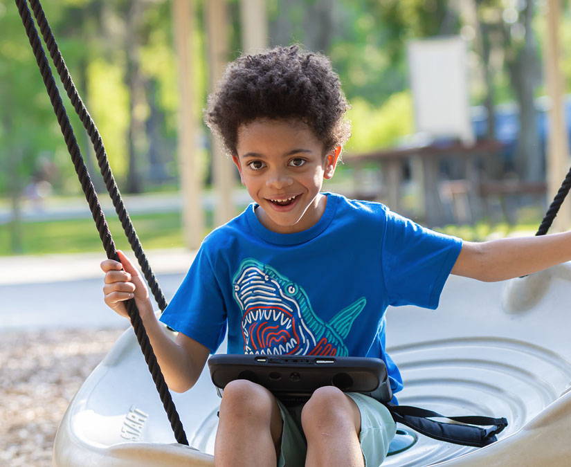 A young boy with autism using Tobii Dynavox AAC app and TD I-110 speech generating device at the playground