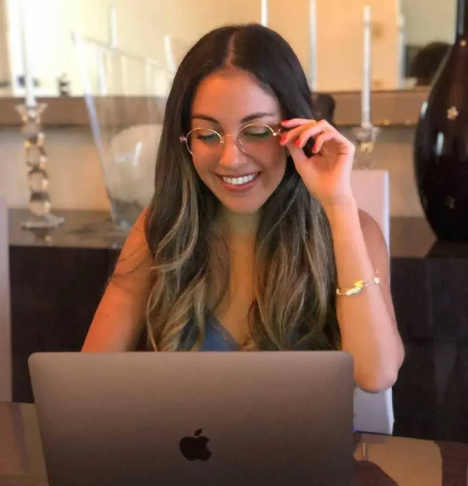 Femme portant des lunettes de lecture devant un ordinateur
