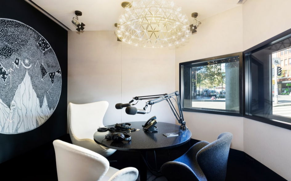 A modern room with a round table, microphone, and large windows.