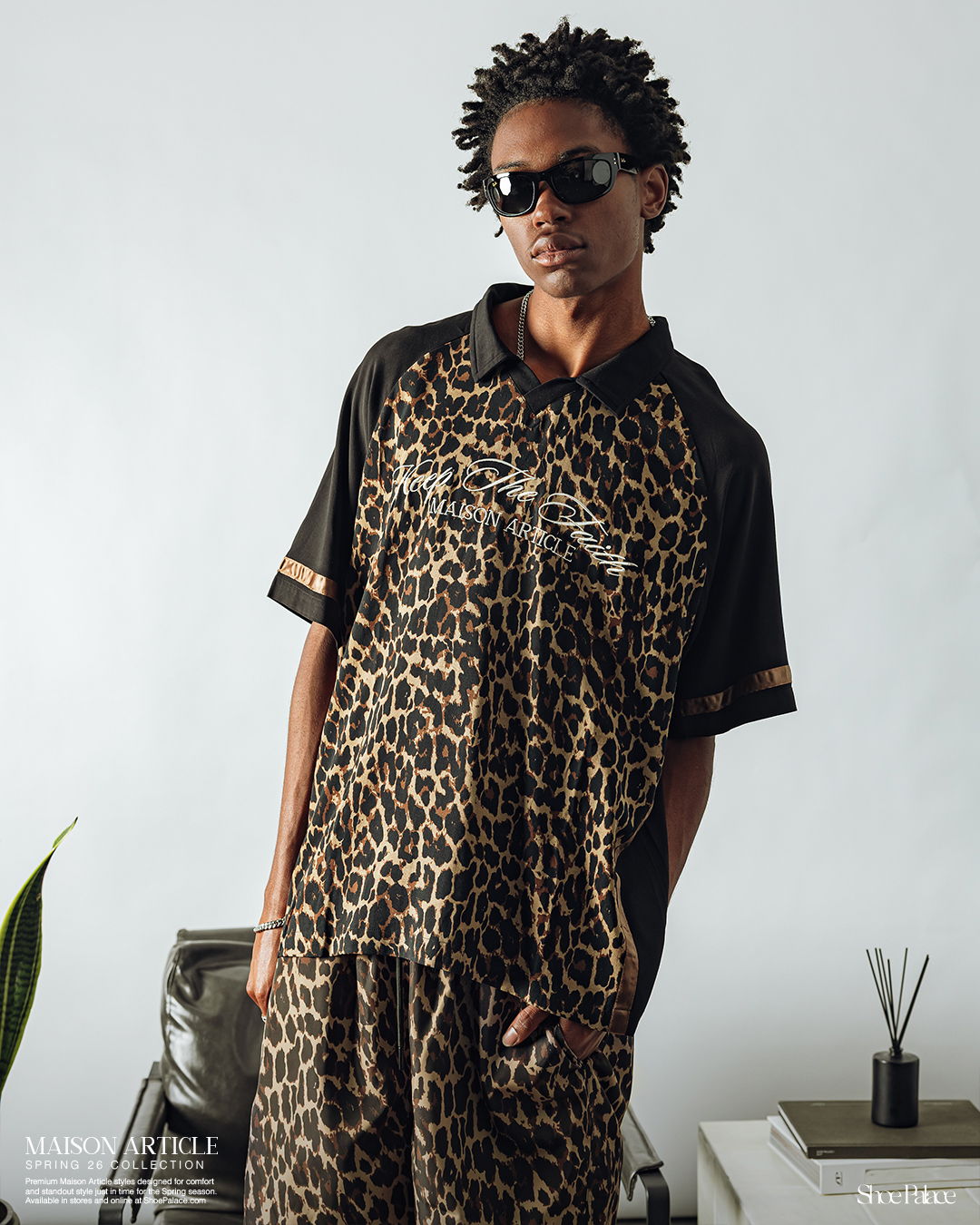 Person wearing leopard print outfit and sunglasses, posing indoors.