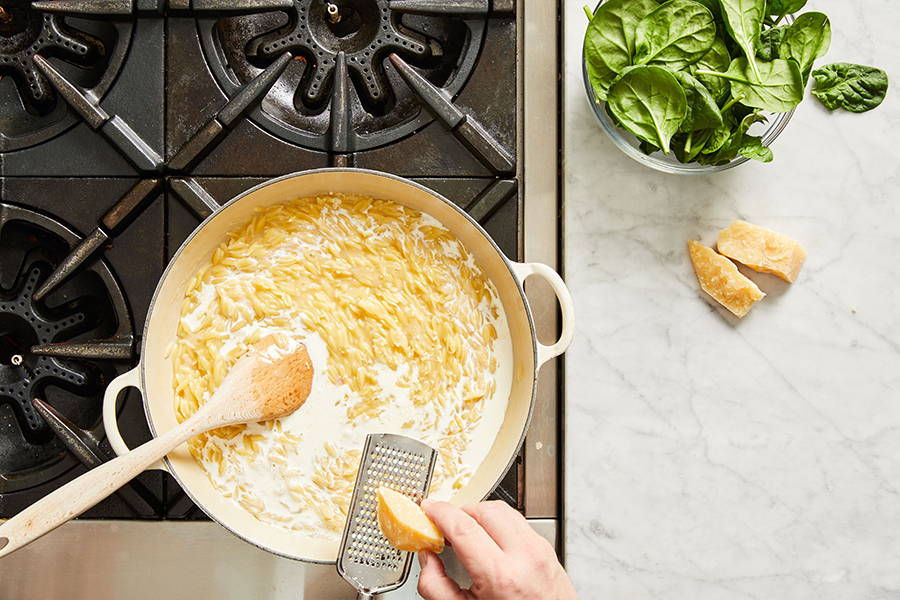 Cheese being grated into pan