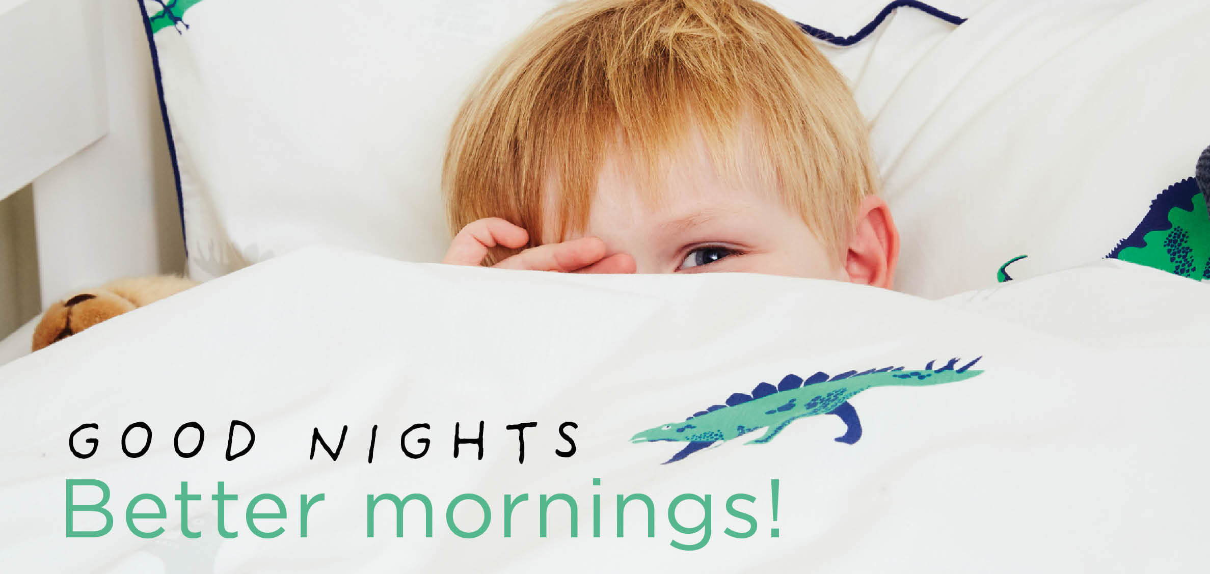 Young boy with dinosaur bedding