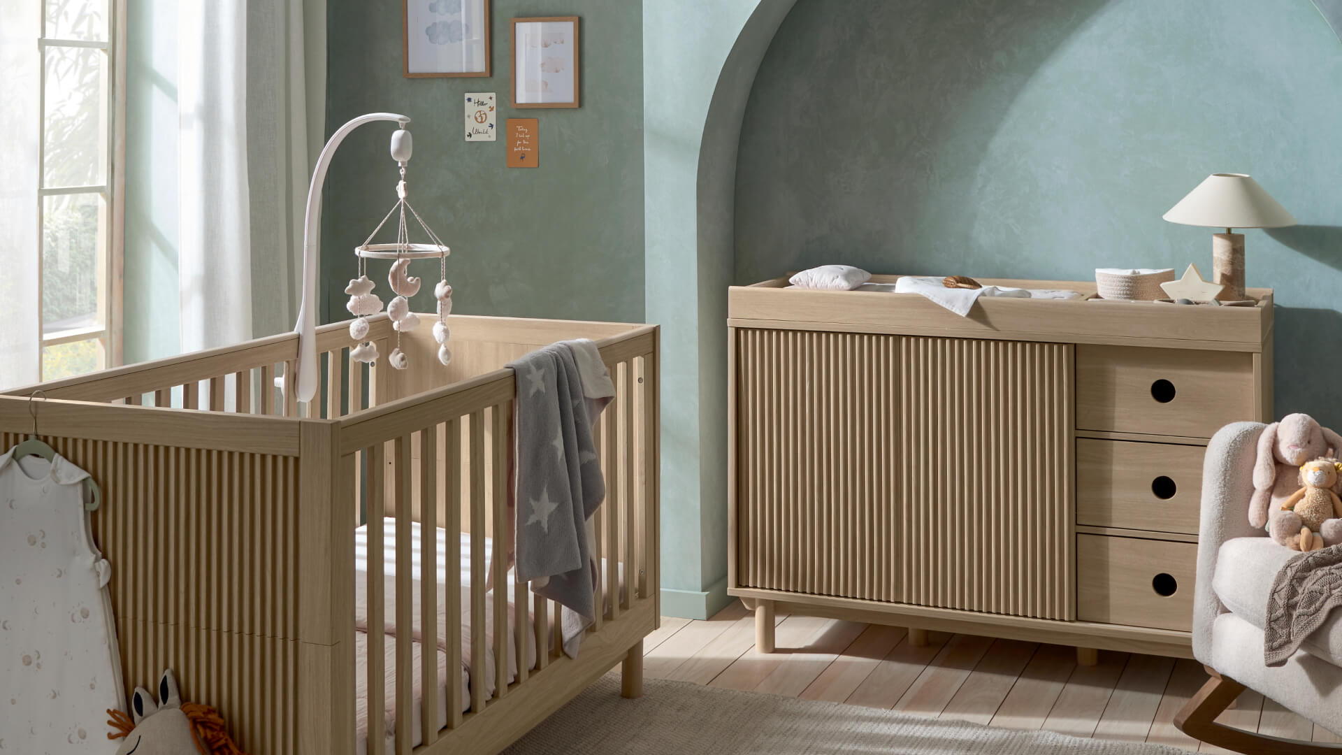 A cozy nursery featuring a wooden crib and changing table.