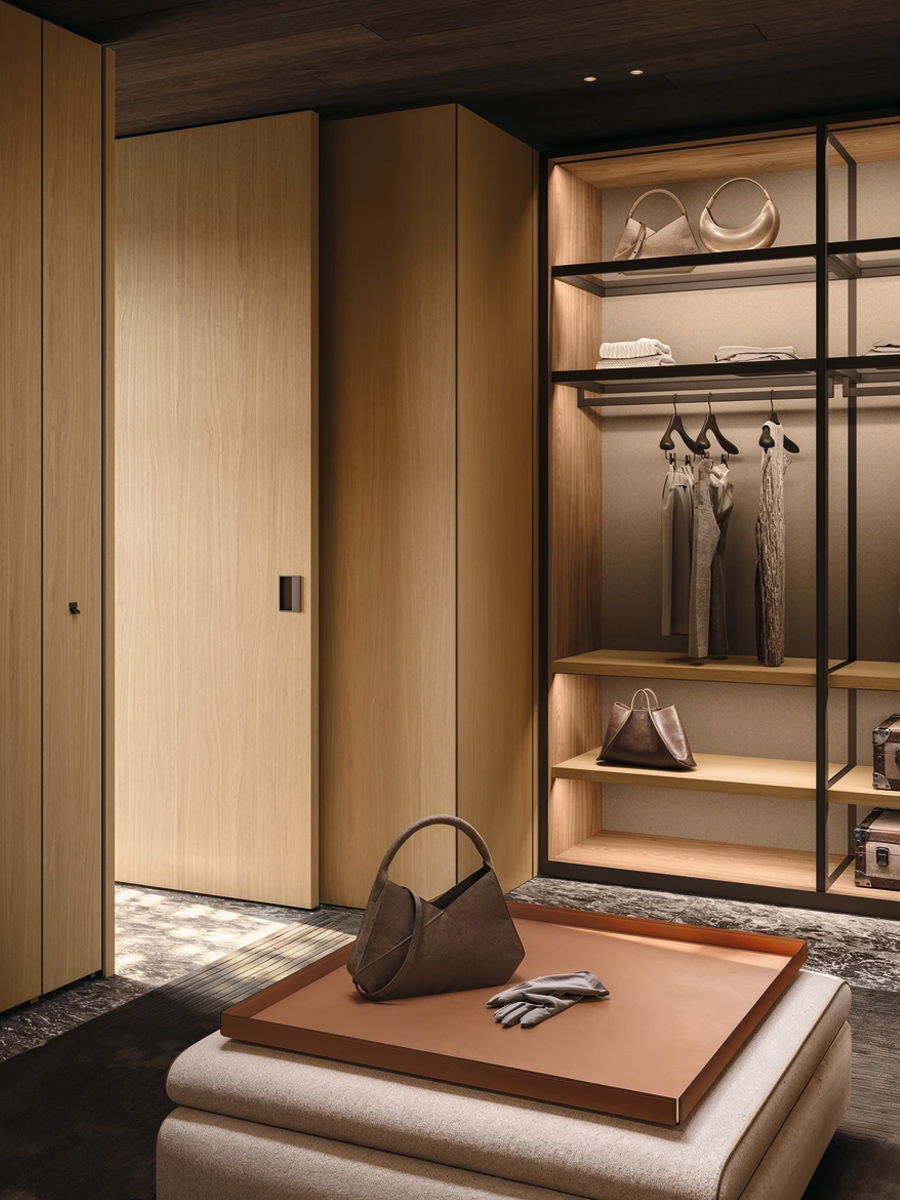 Modern Molteni wardrobe with clothing, accessories, and a stylish handbag on a table.