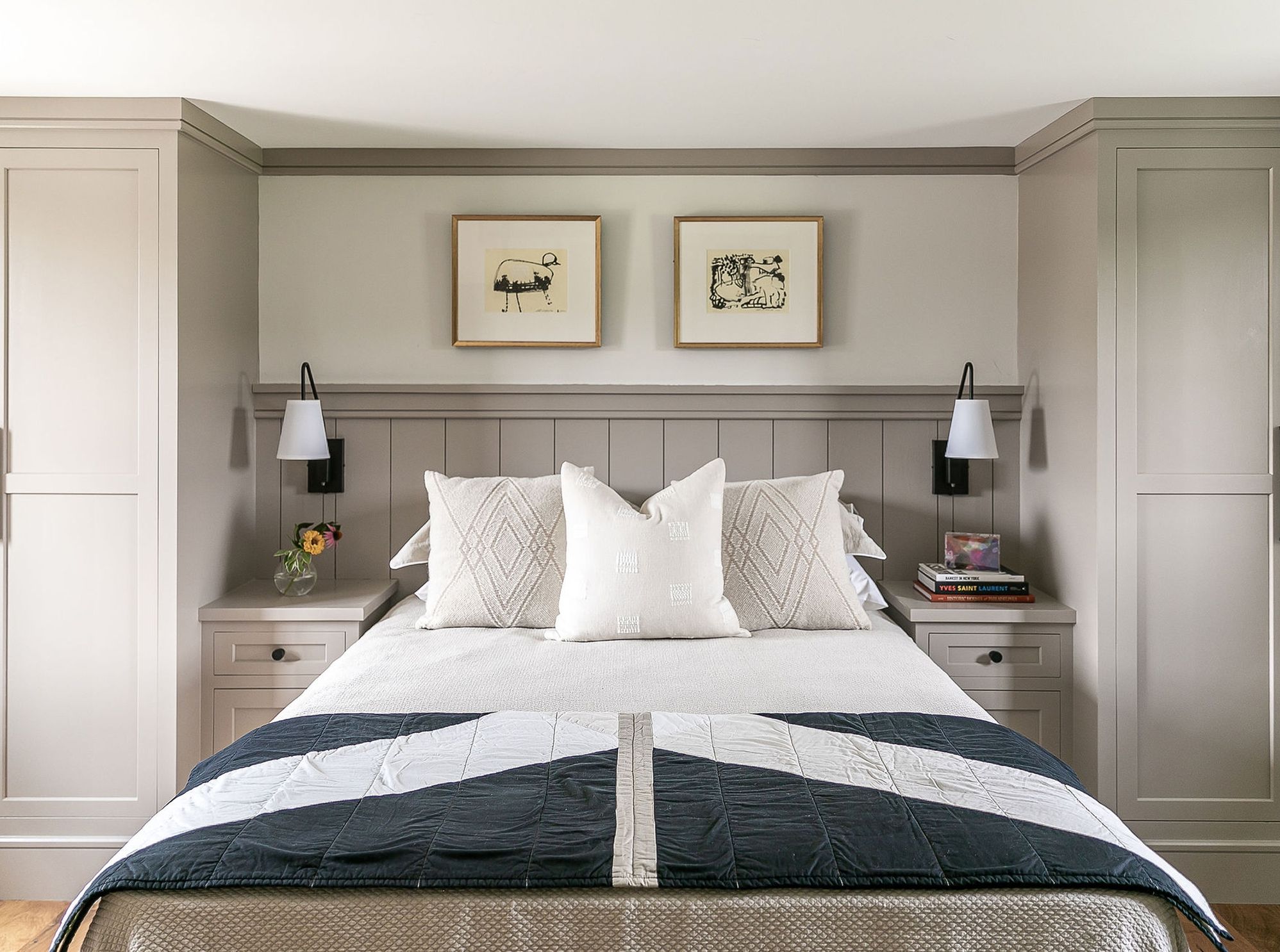 Cozy bedroom with a bed, decorative pillows, and framed artwork on the walls.