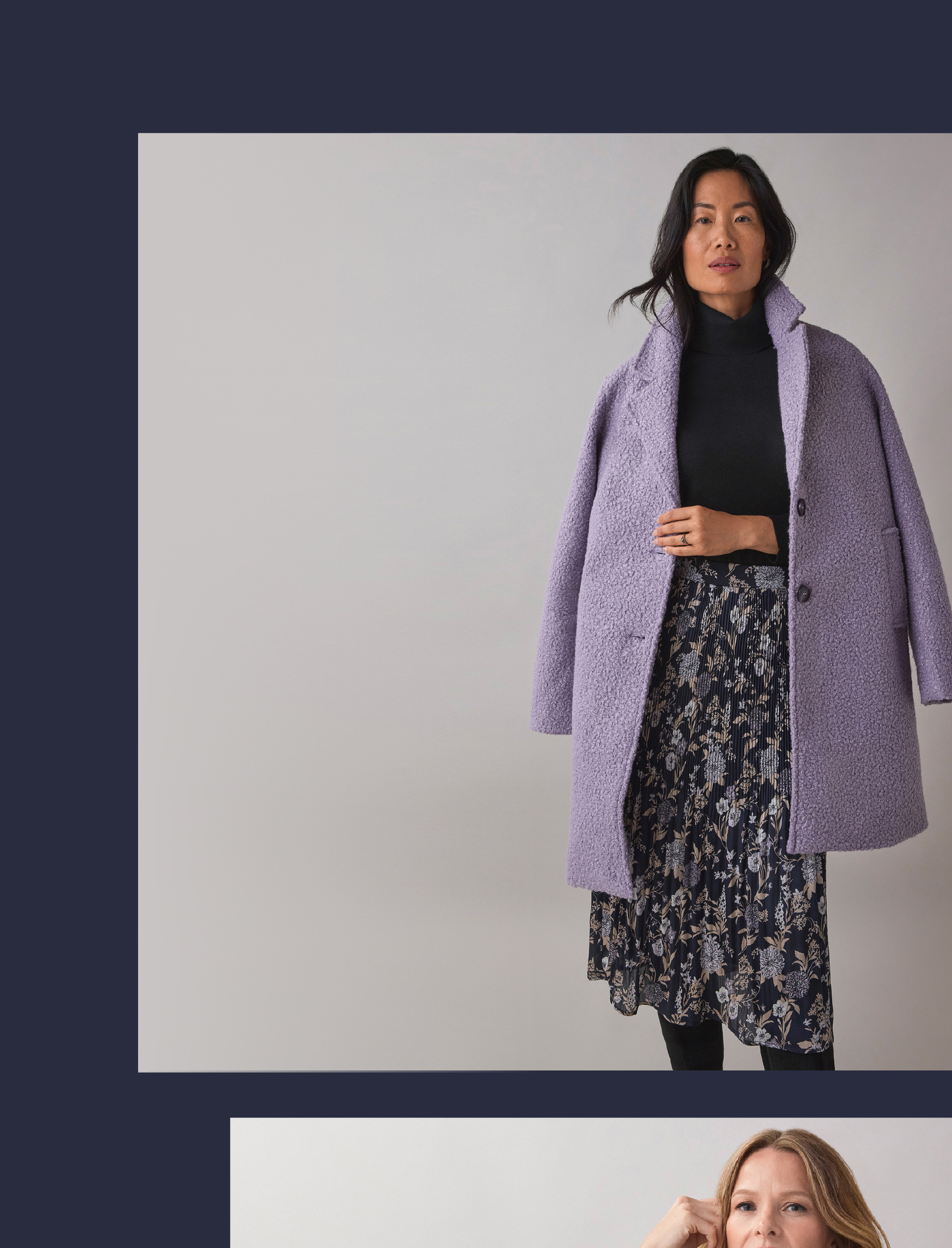 Woman in a lavender coat over a black top and floral skirt.
