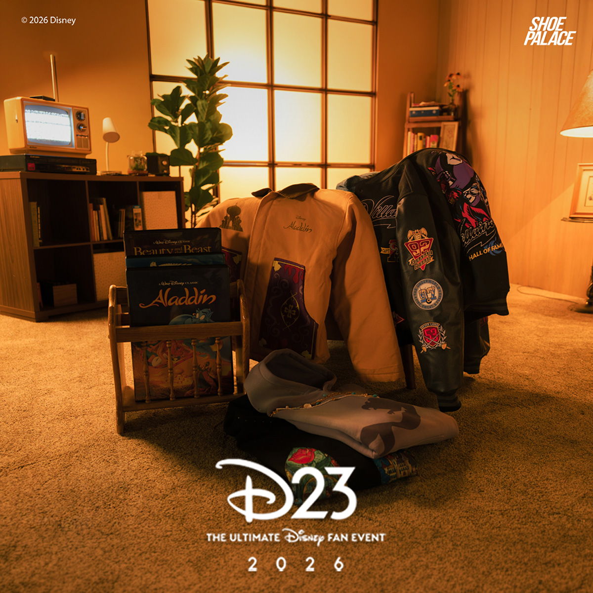 D23 event display featuring clothing, books, and decor in a cozy setting.