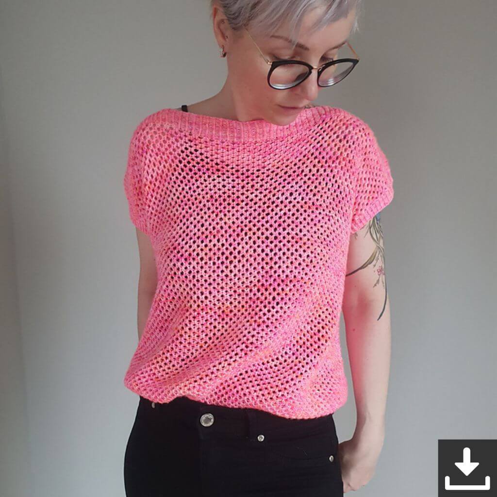 Eine Person, die ein pinkes Strickoberteil und schwarze Jeans trägt und nach unten schaut.