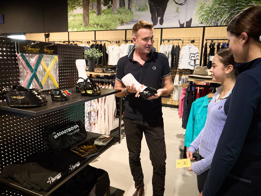 James Arkins shows Scootboots to two customers in a Horseland store.