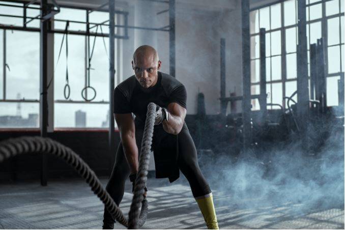 man using battle ropes|individual training vs group training|what is best for you