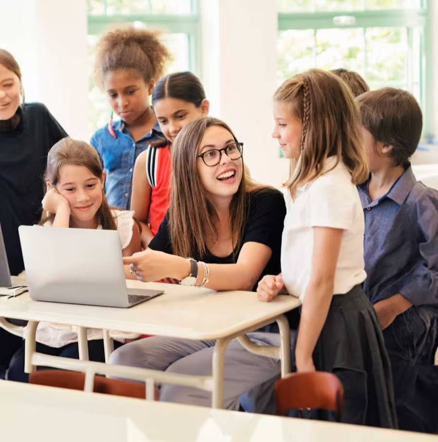 A teacher teaching her students with a laptop