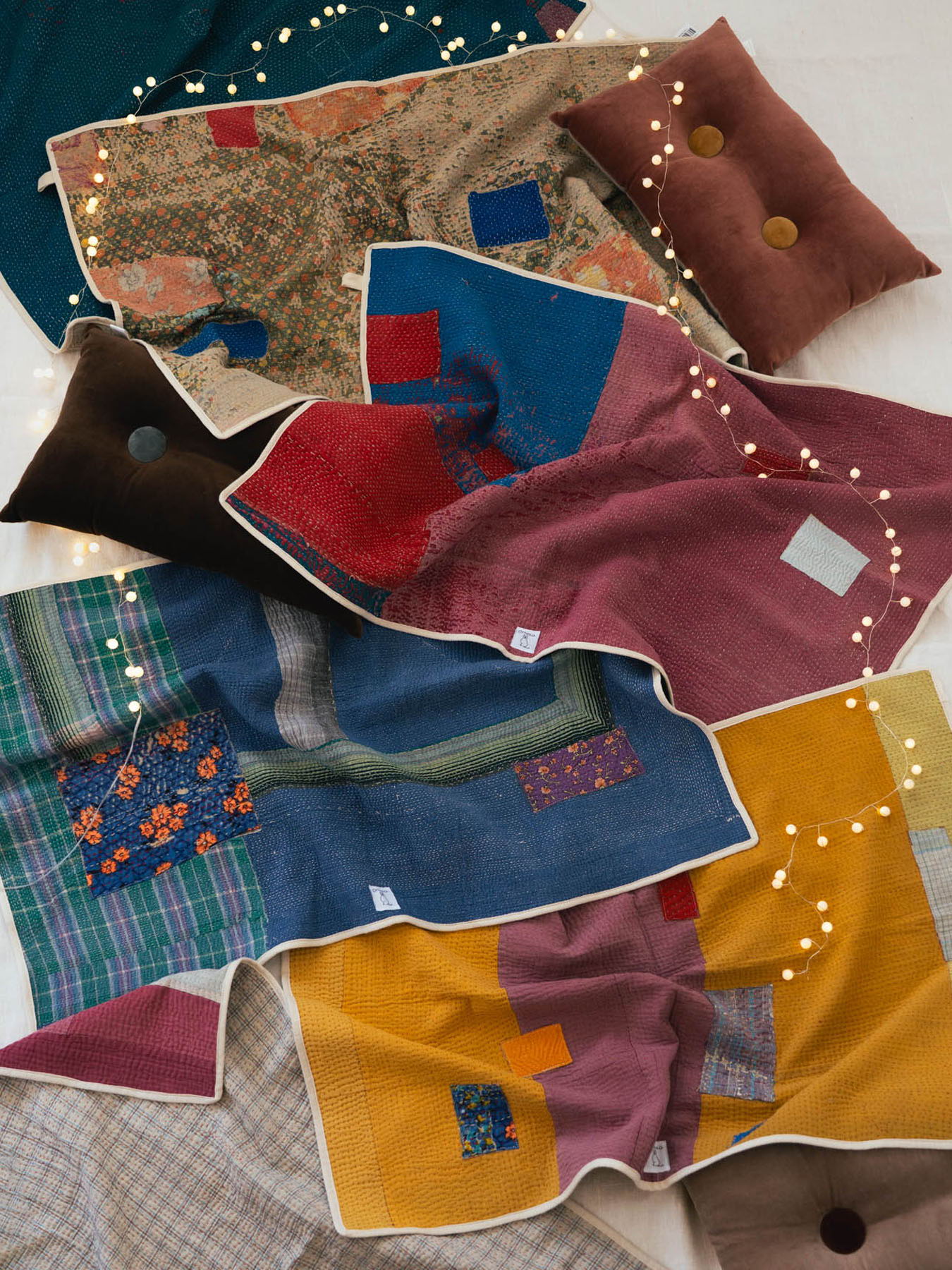 A colorful arrangement of various patterned and textured textiles and cushions.