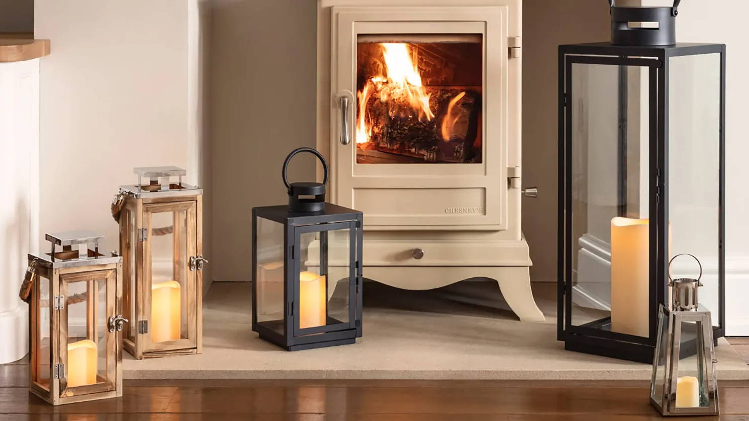 Assortment of indoor lanterns arranged in front of lit fireplace