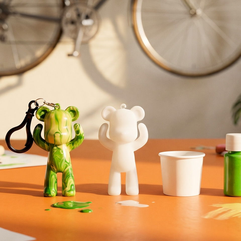 Colorful bear figurines on an orange table with art supplies.