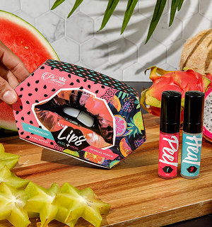 Cosmetic products displayed with tropical fruit on a wooden surface.