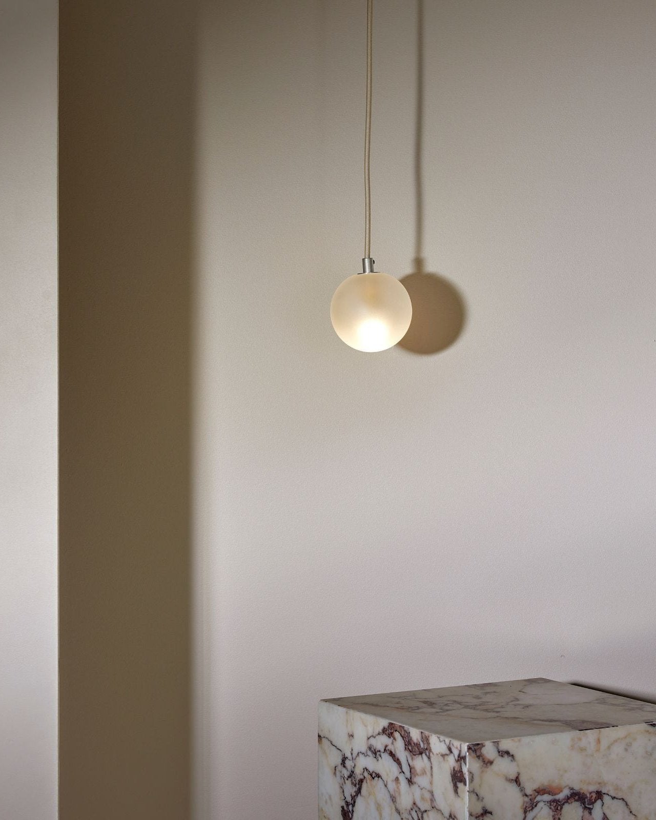 Modern pendant light with a marble table in the background