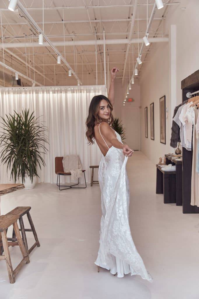 Bride in the Grace Loves Lace USA showroom wearing the low back Loyola wedding dress