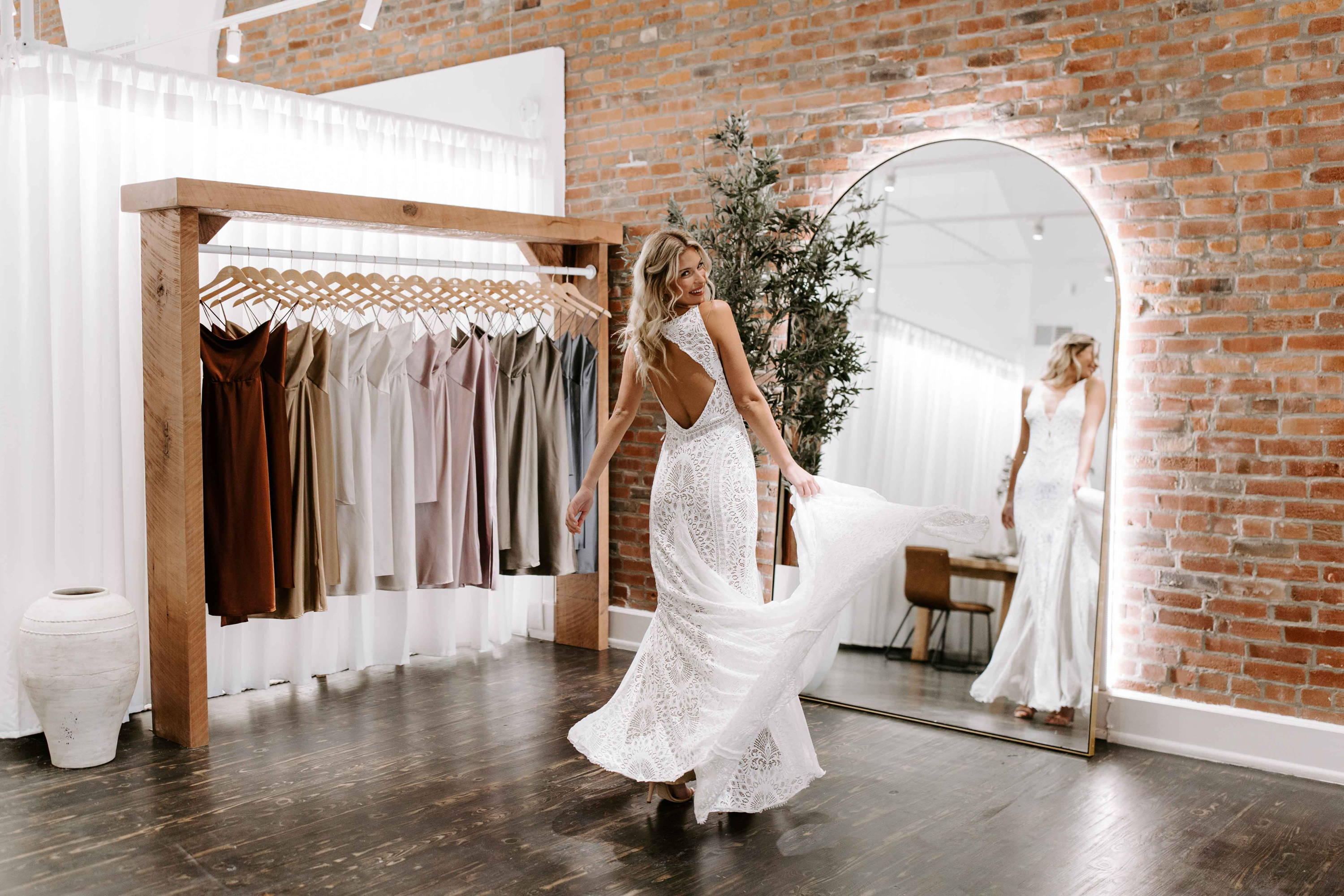 Bride twirling in showroom in front of mirror