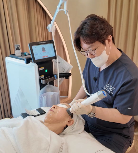 A dermatologist performing a facial treatment on a patient in a clinic.