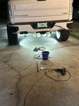 White train horns mounted under rear bumper with underglow during night install on Joel's Silverado photo 3