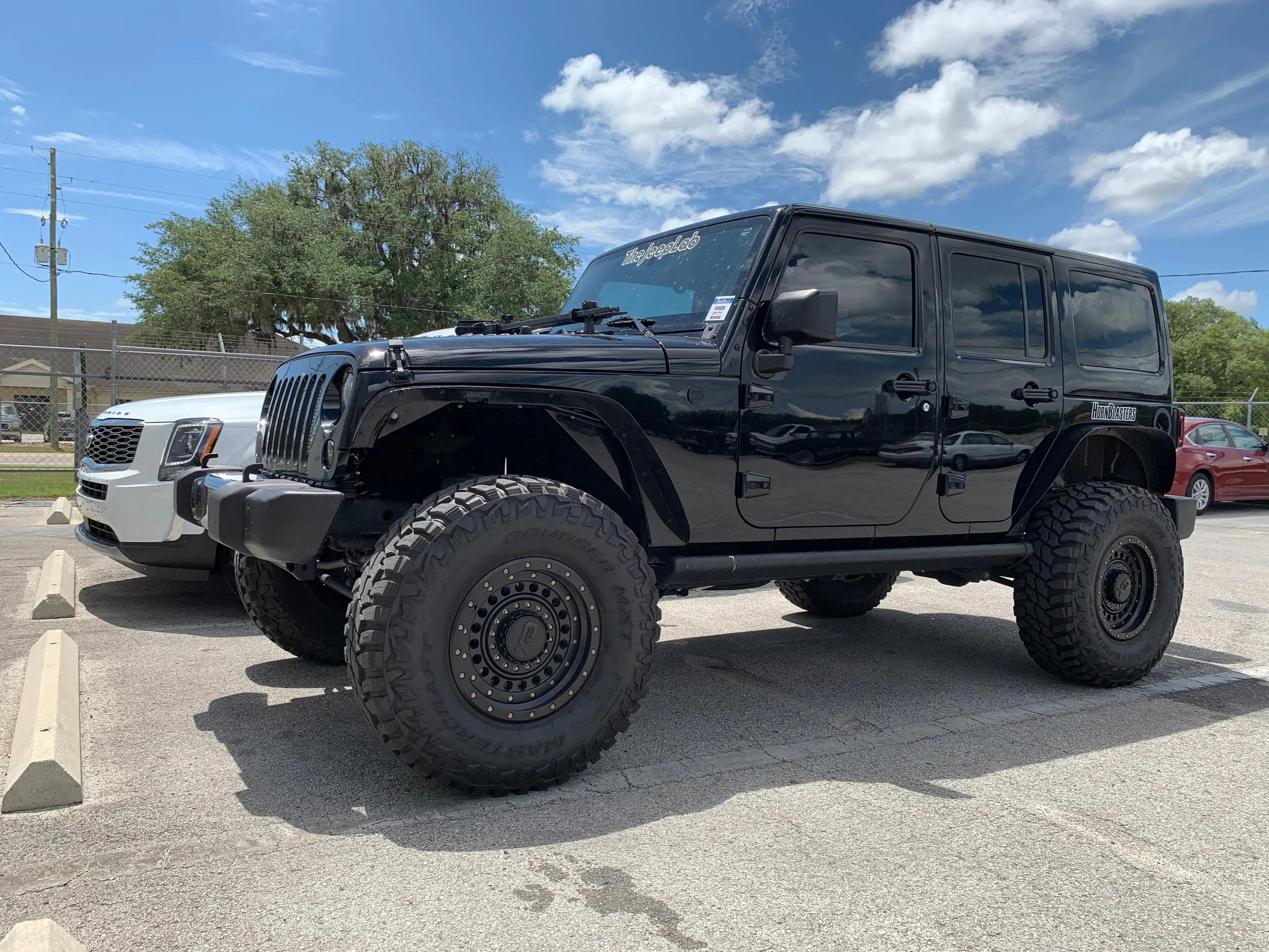 Front-three-quarter Annie's 2017 Jeep Wrangler JKU four-door exterior Jeep grille Wrango Horn Kit featured install photo 1
