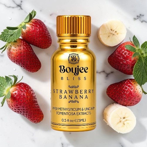 Gold bottle of Boujee Bliss Strawberry Banana surrounded by strawberries and banana slices.