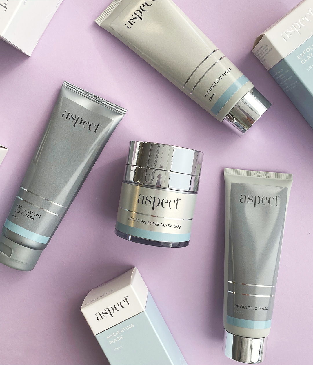 Aspect skincare tubes and jars arranged on a lilac background