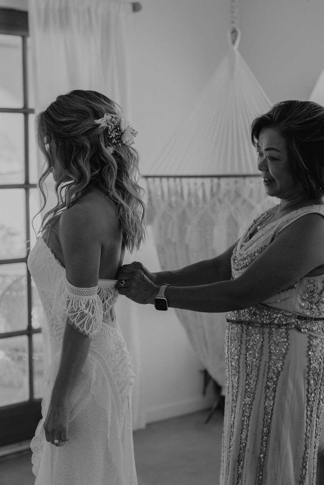 Mother of the Bride helping Bride get into her gown