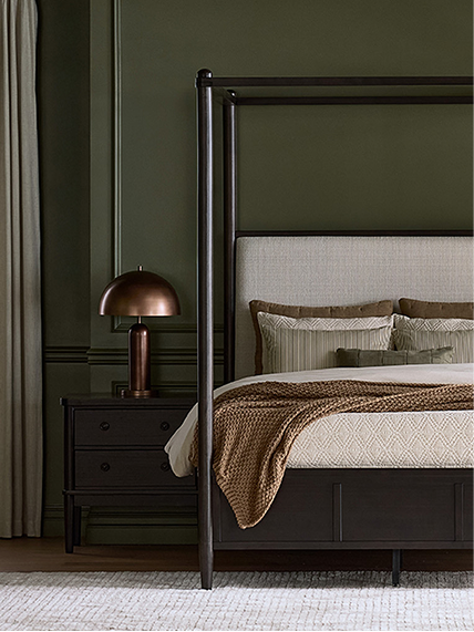 Dark-toned bedroom featuring a statement bed, moody palette, and layered bedding.