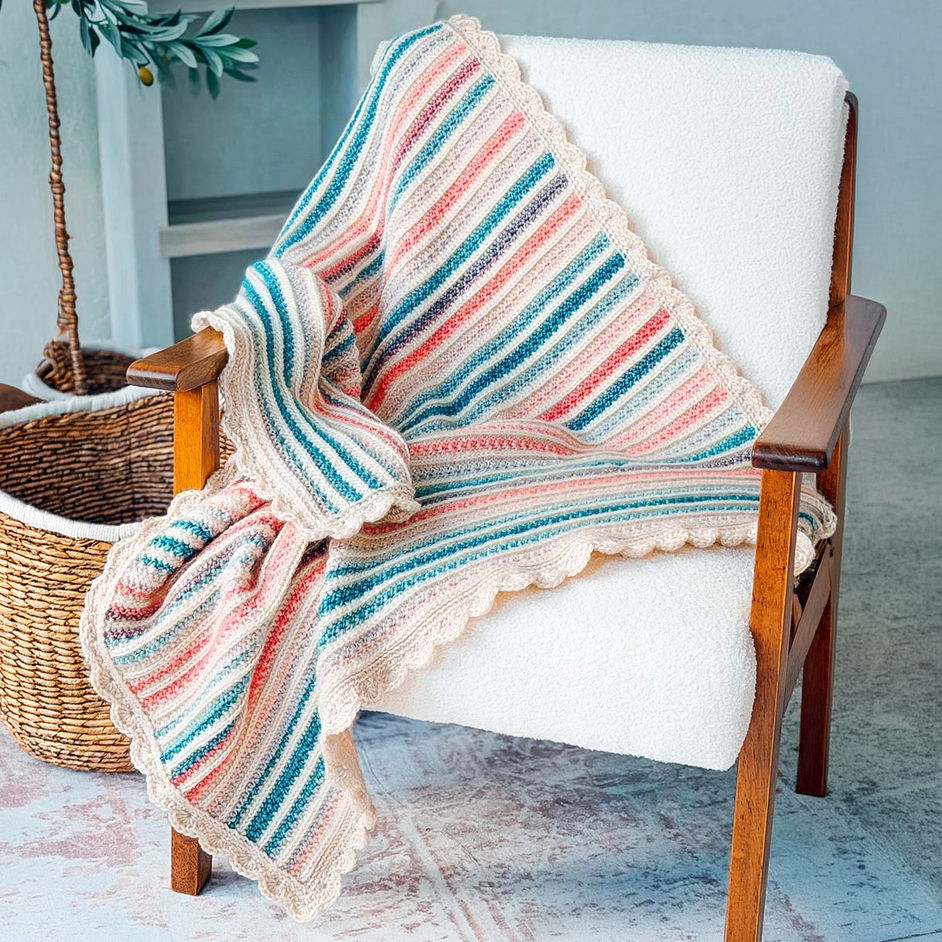 A striped blanket draped over a wooden chair in a cozy setting.